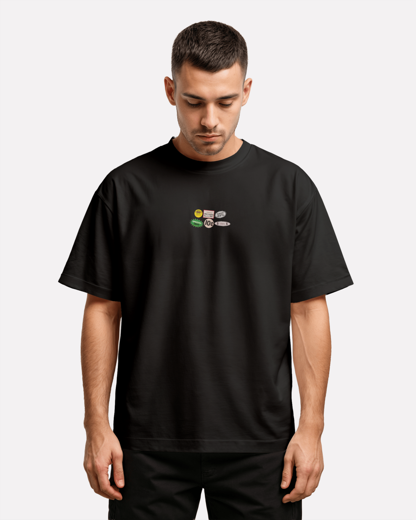 Man wearing a blanc black t-shirt with vintage sticker designs on a plain background